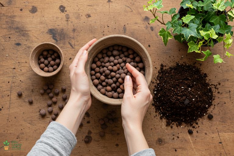 Mãos preparando um vaso com camada de drenagem no fundo antes de adicionar o substrato para a Hera Inglesa.